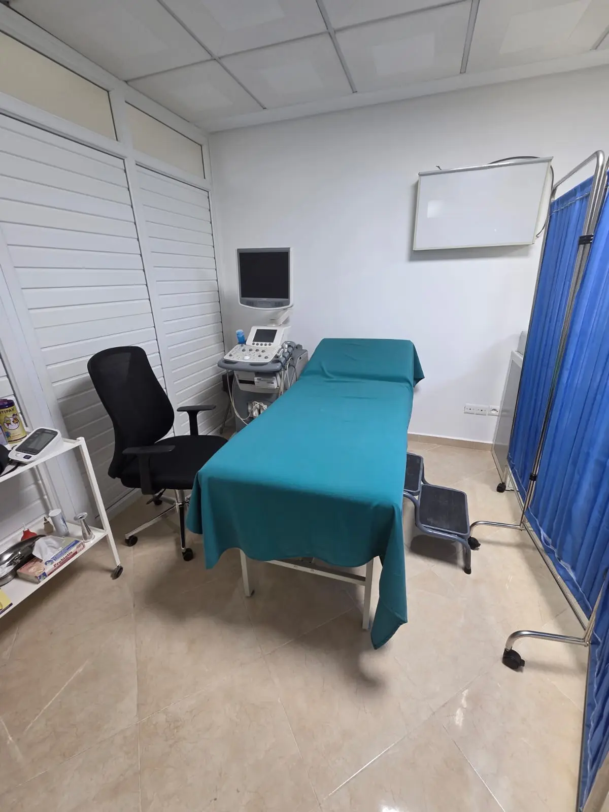 Salle d'échographie équipée d'un appareil à ultrasons moderne pour diagnostics précis au cabinet du Dr. HAMYA